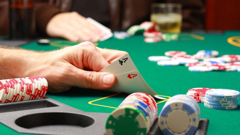 Man playing pokerMan checking his cards during poker game ID 4